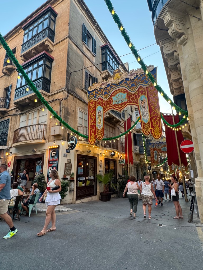 A street corner in Valetta, Malta. There are large religious banners hung up across the street.