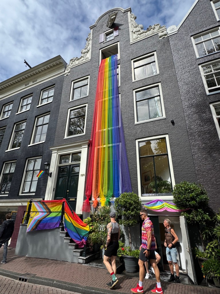 Rainbow colours draped down the front of an Amsterdam canal house