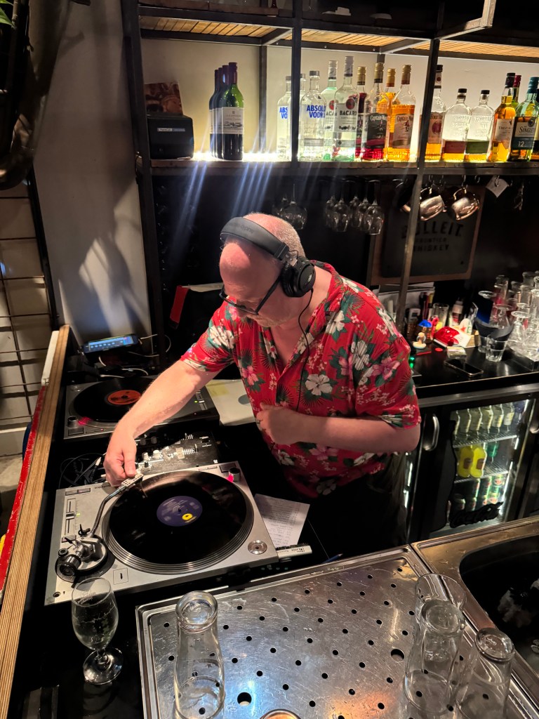 A man in a red Hawaiian shirt, on the decks