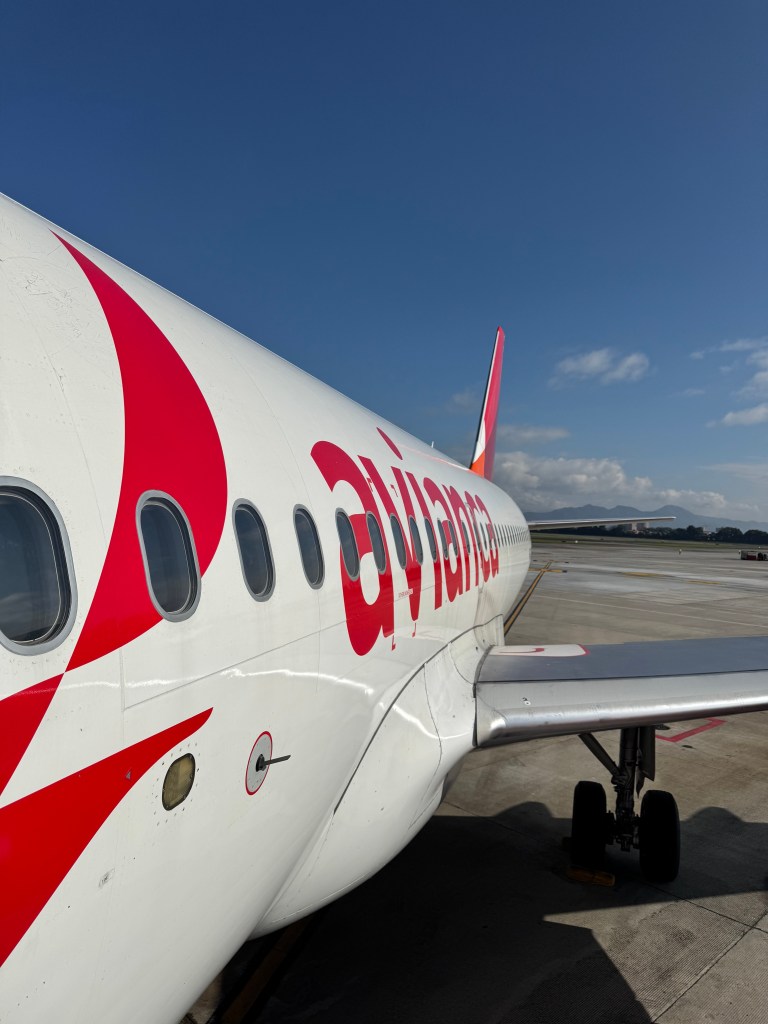 Close-up view of an Avianca airline airplane on the tarmac with a clear blue sky in the background.